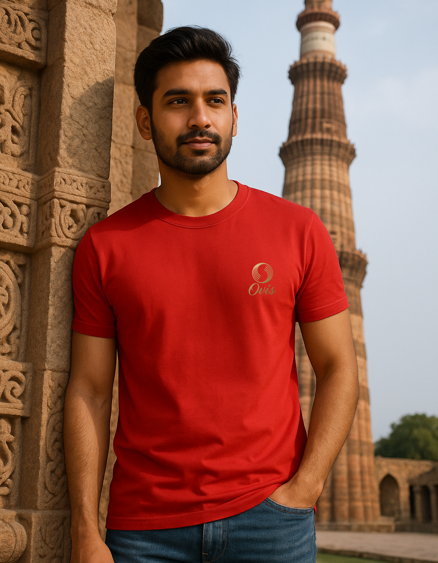 Man wearing a red t-shirt with a logo in front of a historical building