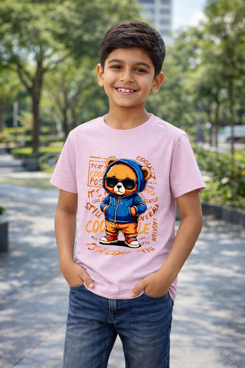 Child wearing a pink t-shirt with a cartoon bear design outdoors.