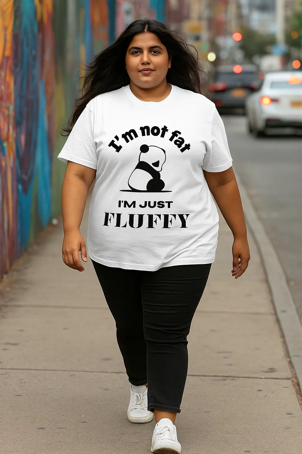 Person wearing a white t-shirt with a panda graphic and text walking on a sidewalk.