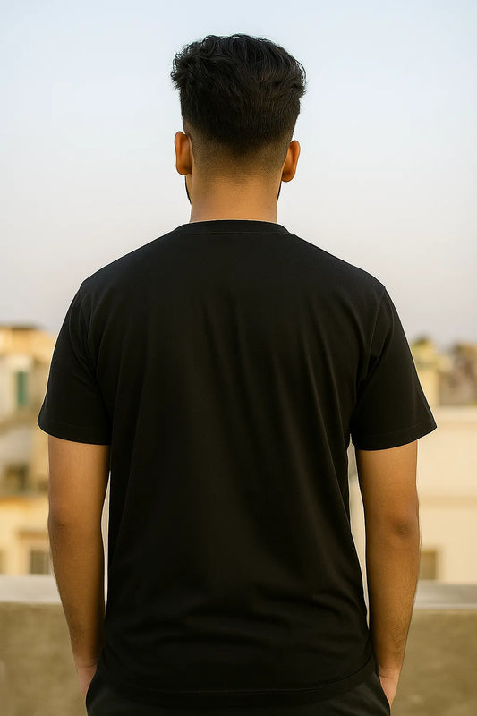 Person wearing a black t-shirt with a blurred background